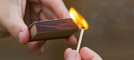 Matchbox and lit match