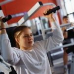 image of woman using shoulder press