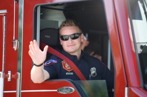 Firefighter waving out of fire engine