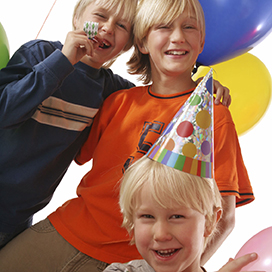 3 boys with birthday party hats and balloons