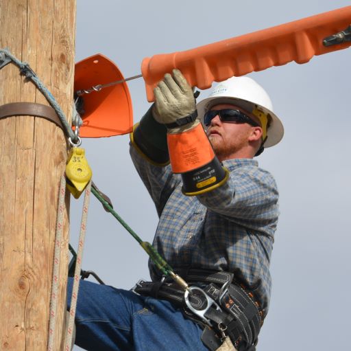 power lineman on a pole fixing a power line